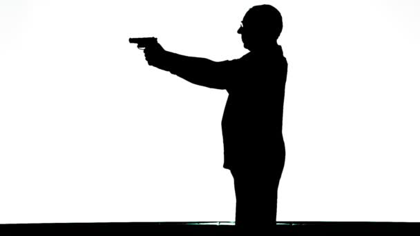 Silhouette d'un homme de profil avec un pistolet sur fond blanc — Video