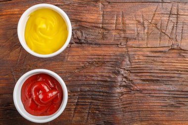 Peynir soslu sos tekneleri ve ahşap bir masada ketçap. Yer ayır. Yatay fotoğraf