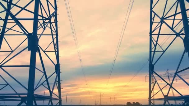 Suporta de linhas de alta tensão de energia contra o pano de fundo do pôr-do-sol vídeo aéreo — Vídeo de Stock