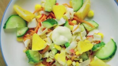 Salatalık ve portakalla süslenmiş yengeç salatası daire şeklinde döner.