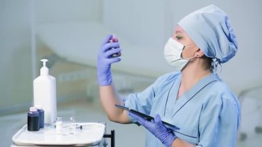 Tıbbi maskeli bir kadın doktor ilaçların son kullanma tarihlerini kontrol eder.
