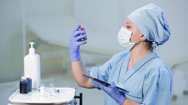 A female doctor in a medical mask checks the expiration dates of medicines — Stock Video