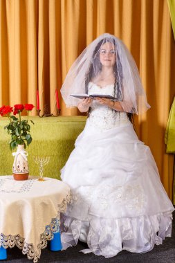 Bereketli beyaz elbiseli mutlu Yahudi gelin hupa töreninden önce mutlu bir evlilik için dua ediyor..