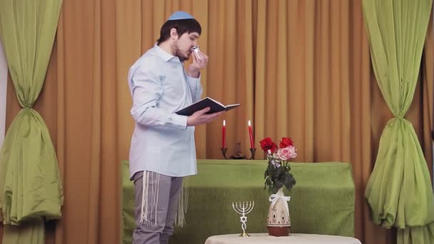 Before the chuppah ceremony, the Jewish groom reads prayers and psalms for siddur in the synagogue hall and makes kiddush for wine — Stock Video