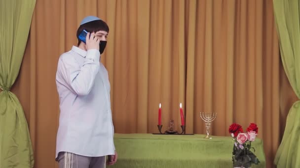 Перед церемонією чуппи, єврейський наречений у захисній масці в залі синагоги розмовляє по телефону. — стокове відео
