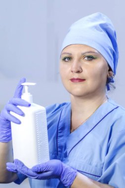 Eldivenli bir doktor elinde antiseptik tutuyor. Dikey fotoğraf