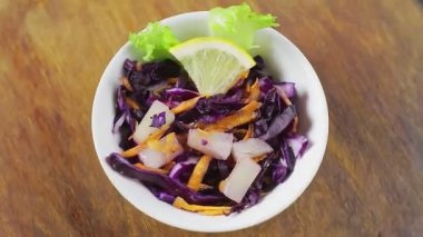 Tahta tezgahta limonla süslenmiş ananaslı Cole yavaş salatası daire şeklinde döner..