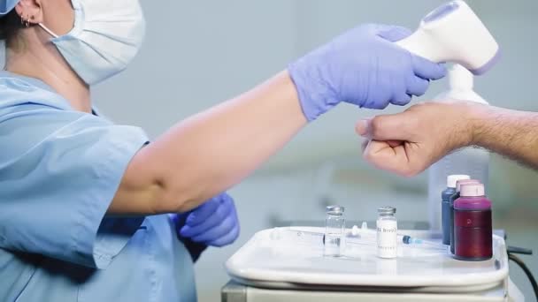 Der Arzt misst die Temperatur des Patienten mit einer Wärmebildkamera am Arm — Stockvideo