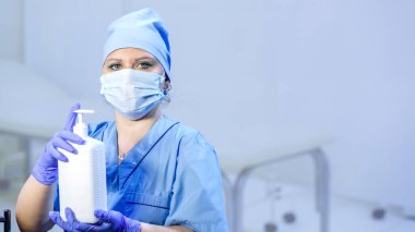 Eldivenli ve maskeli bir doktor elinde antiseptik tutuyor. Yatay fotoğraf