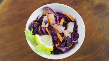 Tahta tezgahta ananaslı Cole yavaş salatası daire şeklinde döner..