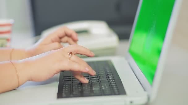 Female hands are typing on the laptop keyboard in the home office — Video