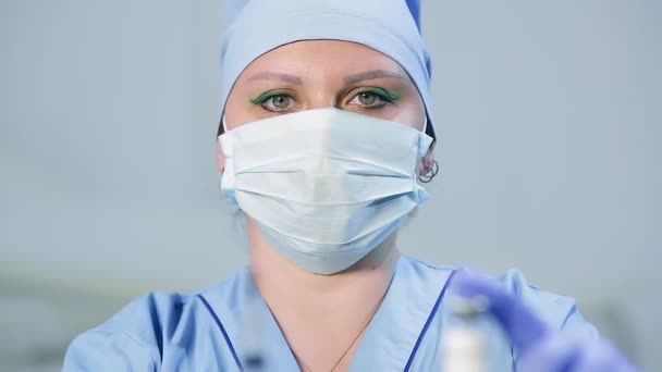 Szczepionka i strzykawka w rękach lekarki twarzy z rozmyciem w ostrości. — Wideo stockowe