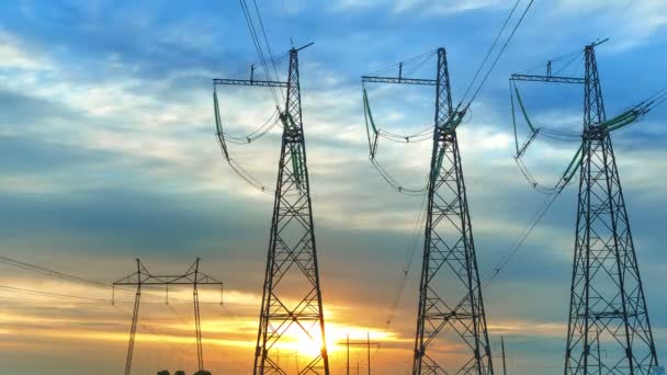 Las torres de transmisión de energía contra el fondo del cielo y el sol poniente con nubes corriendo vueltas de tiempo — Vídeos de Stock