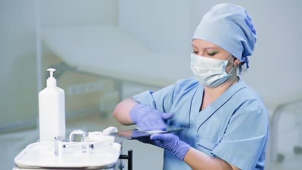 Woman doctor in a medical mask disinfects the tablet — Stock Video