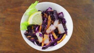 Tahta tezgahta ananaslı Cole yavaş salatası daire şeklinde döner.