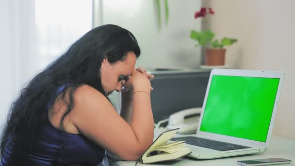仕事に疲れたブルネットの女性は自宅のオフィスでコンピュータに座っている — ストック動画