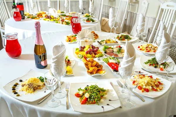 Laid banquet table with snacks and fruits and champagne. Horizontal photo