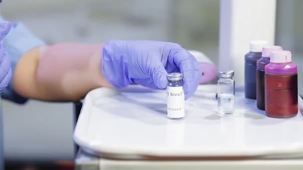 A female doctor is filling a syringe with a vaccine — Stock Video