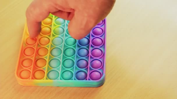 Pop it toy antistress rainbow fingers press round pieces. — Stock video