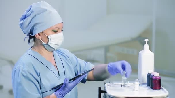 Un medico donna con una maschera medica controlla le date di scadenza dei medicinali — Video Stock