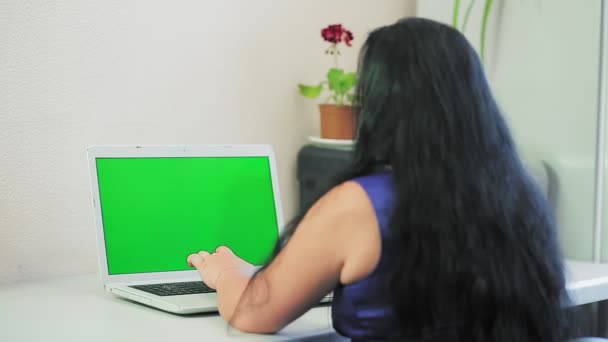 ブルネットの女性は緑の画面カメラに戻ると自宅のオフィスでコンピュータで動作します — ストック動画