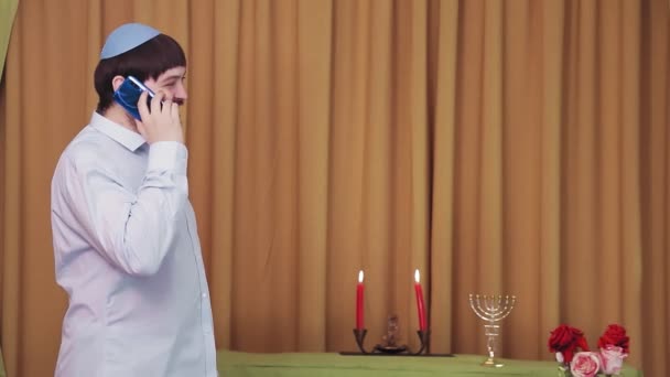 Före chuppá-ceremonin talar den judiska brudgummen i telefon i synagogahallen. — Stockvideo