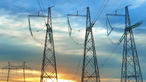 Las torres de transmisión de energía contra el fondo del cielo de la noche y el sol poniente con nubes corriendo vueltas de tiempo — Vídeos de Stock