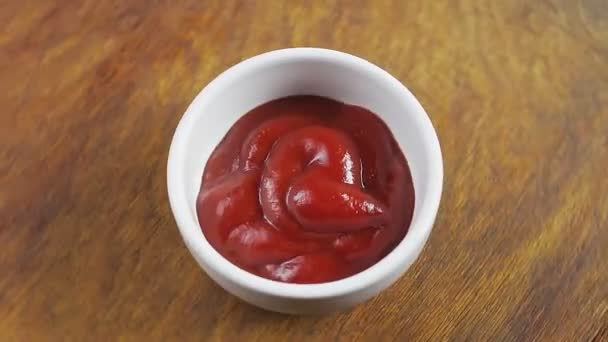 Tomaat ketchup in een witte jus boot op een houten statief draait in een cirkel — Stockvideo