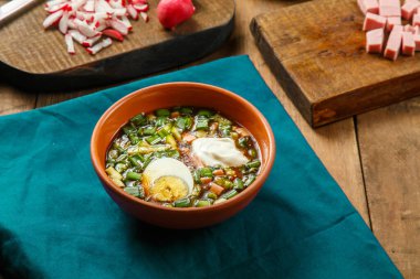 Okroshka kil tabakta, masanın üstünde, masada sebzelerin yanında..