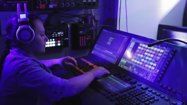 Una donna lighting designer controlla gli apparecchi di illuminazione sul palco della console — Video Stock