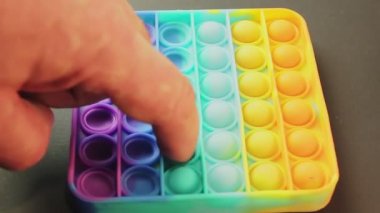 Masada renkli bir pop var. Stres giderici. İnsan parmakları üzerine bastırıyor..