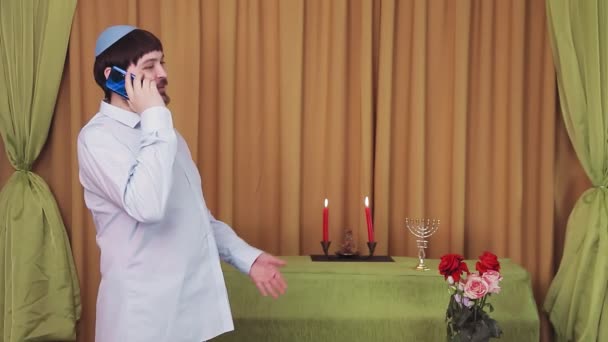 Före chuppá-ceremonin talar den judiska brudgummen i telefon i synagogahallen. — Stockvideo