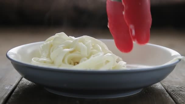 A fogók az udon tésztát fogóval teszik az asztalra.. — Stock videók