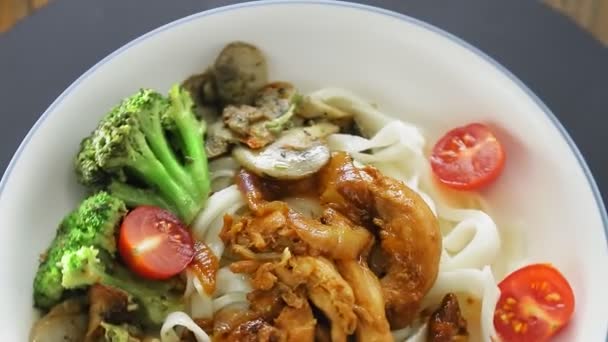 Talerz udon z mięsem w yakiniku sosie i zieleninie czytuje kruszony w kole. — Wideo stockowe