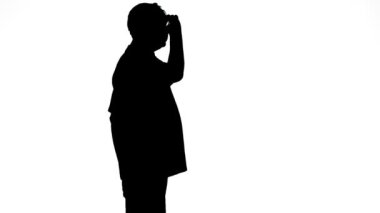 Beyaz arka planda ateş eden profilli bir adamın silüeti.