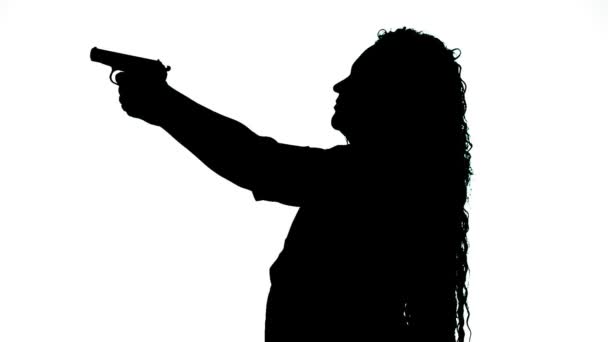 Silhuett av en kvinna på en vit bakgrund skjuta en pistol. — Stockvideo