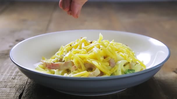 Une main de femme décore avec des pâtes carbonara au fromage dans une assiette — Video