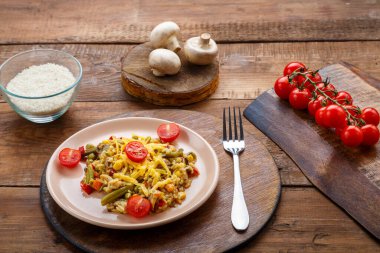 Tavuklu pilav ve peynirli pilav mantarları ve domateslerin yanında yuvarlak bir tezgahta, ahşap bir arka planda. Yatay fotoğraf