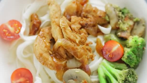 Talíř udonu s kuřetem v yakiniku omáčce a zelenině se rozpadá v kruhu — Stock video