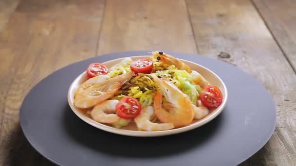 Platos de espaguetis en una salsa cremosa con camarones y tomates cherry girando en círculo. — Vídeos de Stock