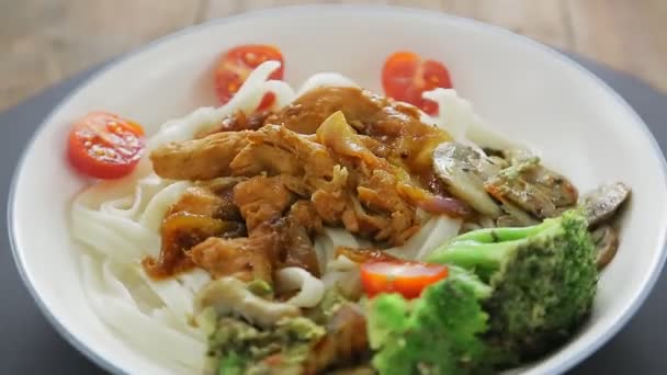 Ένα πιάτο udon με κοτόπουλο σε σάλτσα yakiniku και λαχανικά καταρρέει σε έναν κύκλο. — Αρχείο Βίντεο