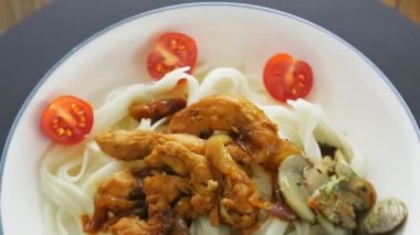 Yakiniku soslu bir tabak udon ve sebzeler bir daire şeklinde ufalanır..