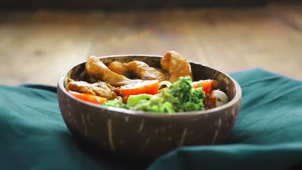 М'ясо в соусі рібейку з удоном і овочами на тарілці на синій серветці обертається навколо — стокове відео