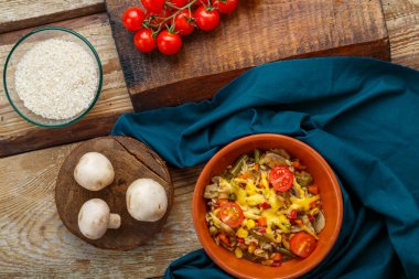 Ahşap bir arka planda mantarlı pilav, mavi peçete ve malzemeler. Yatay fotoğraf