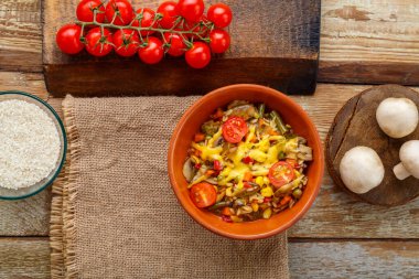 Tabakta mantarlı risotto, ahşap bir arka planda, peçete ve malzemeler. Yatay fotoğraf