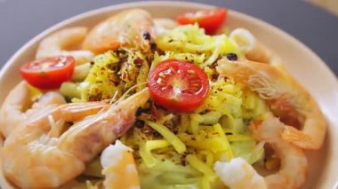 Kremalı soslu makarna, tabakta karidesler daire şeklinde döner.