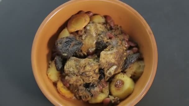 Żydowskie danie chelnt z mięsem na czarnym tle obraca się w kółko — Wideo stockowe