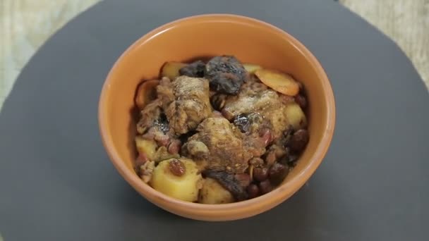 El plato judío quelnt con carne en un soporte negro gira en un círculo — Vídeo de stock