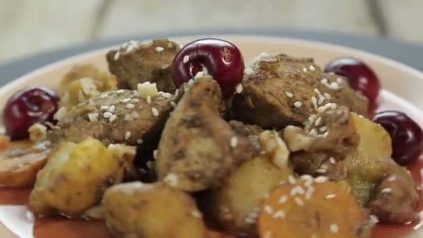 Εβραϊκό ψητό πιάτο με κοτόπουλο σε σάλτσα κεράσι σε πιάτο διακοσμημένο με κεράσια περιστρέφεται σε κύκλο. — Αρχείο Βίντεο