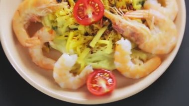 Kremalı soslu spagetti tabakları karides ve çember şeklinde dönen kiraz domatesleri..